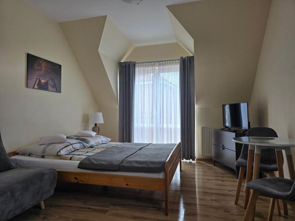 Pokój z dużym łóżkiem, pufą do spania i oknem